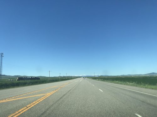 Long road with view of the mountains of Montana